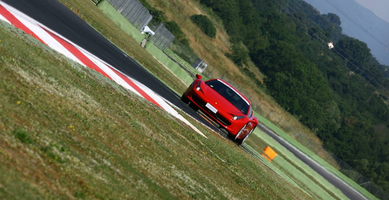 Rote Ferrari durchfährt eine Kurve auf einer Rennstrecke nahe Mailand
