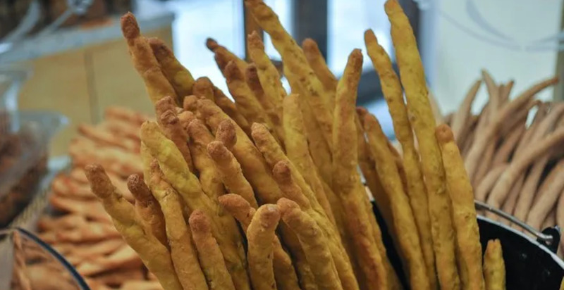 Handgemachte Grissini serviert mit piemontesischem Wein während einer Street-Food-Tour in Turin