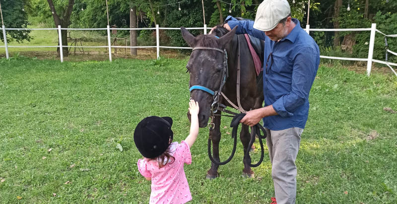 Kinder lernen Pferde auf einer Ranch inmitten der Natur kennen