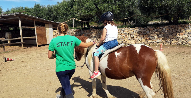 Reiten im Parco Asinolla Mädchen reitet auf Pferd