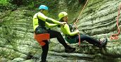Teilnehmer beim Abseilen unter einem Wasserfall in der Garfagnana