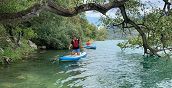 Personen auf einem SUP-Board in der Baia del Corno am Gardasee