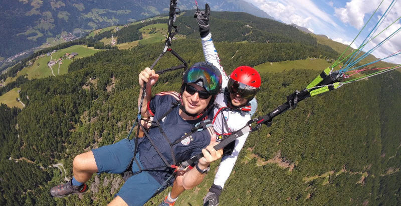 Erfahrener Pilot führt einen Tandem-Paragliding-Flug über Meran